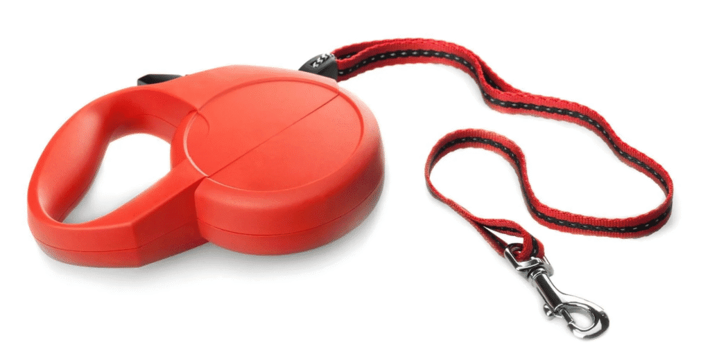 Red retractable dog leash with a flat tape style lead and metal clip laid out on a white background.